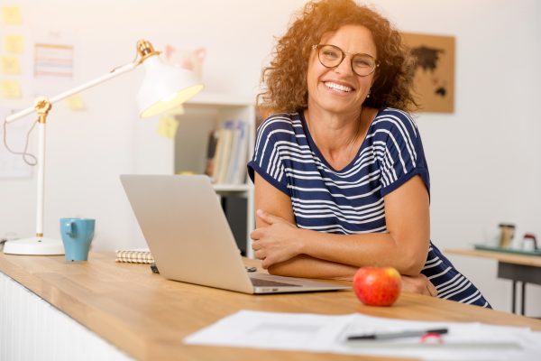 Successful middle aged woman smiling at her office